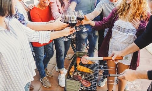 Group toast over a grill of good food