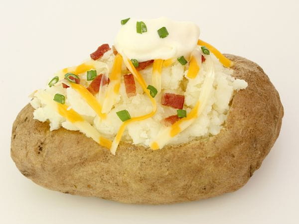Cooked baked potato with sour cream, chives and bacon