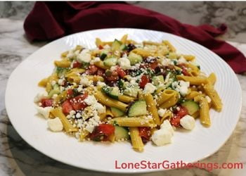 Mediterranean Pasta Salad with cucumbers, tomatoes, kalamata olives, herbs and feta cheese with logo