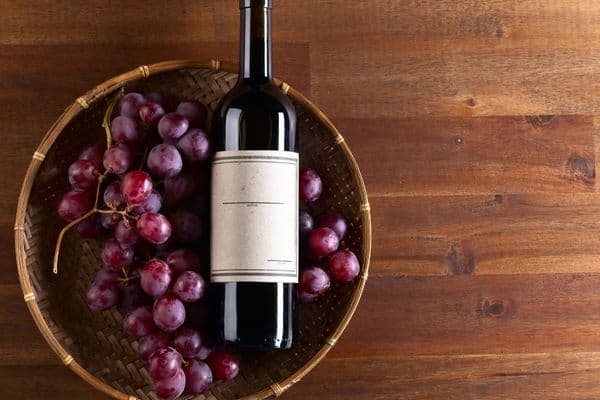 red wine and red grapes in basket
