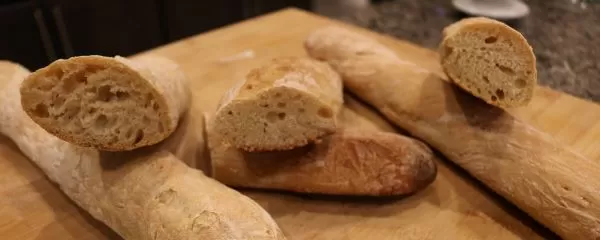 Three homemade baguettes baked without bread flour cut in half