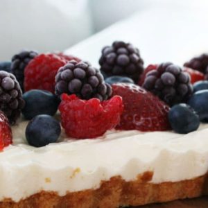 Side view of a slice of no-bake cheesecake loaded with berries