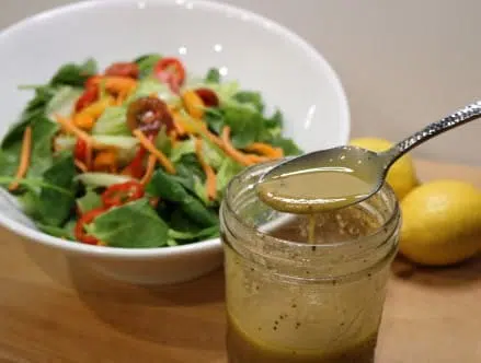 Vinaigrette dressing with a bowl of salad for a Mother's Day Brunch Idea